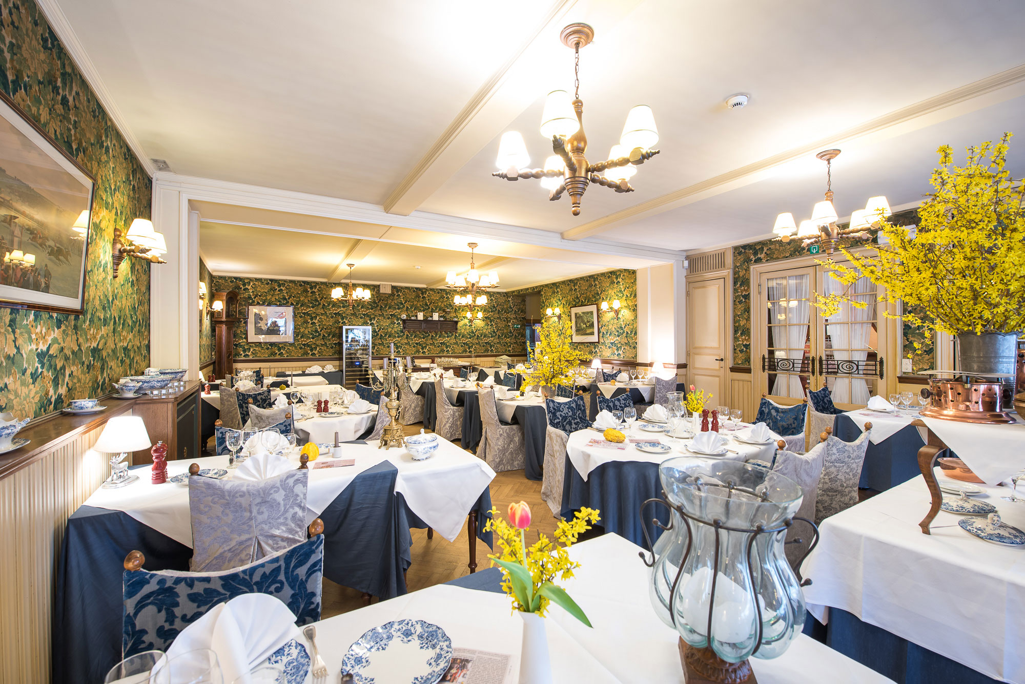 Salle principale du Restaurant Bonhomme avec lustres et tapisserie
